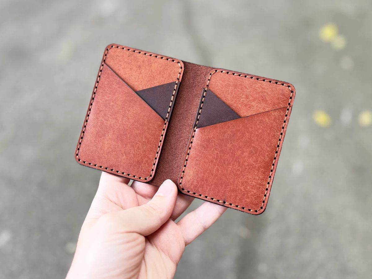 Porta-cartões bifold de couro aberto na mão